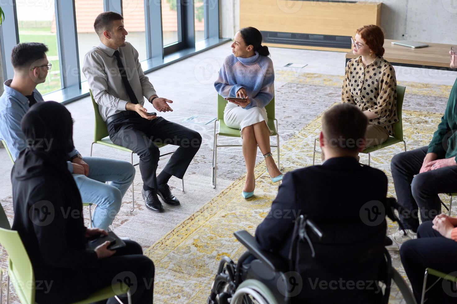 Corporate business team meeting with a manager or coach. Group of happy diverse, multiracial people sitting in a circle photo
