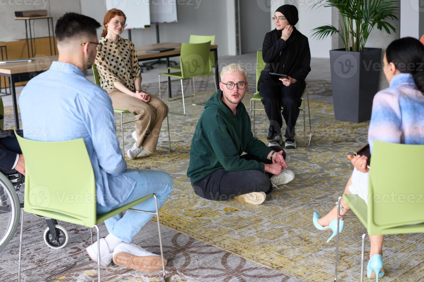 Corporate business team meeting with a manager or coach. Group of happy diverse, multiracial people sitting in a circle photo