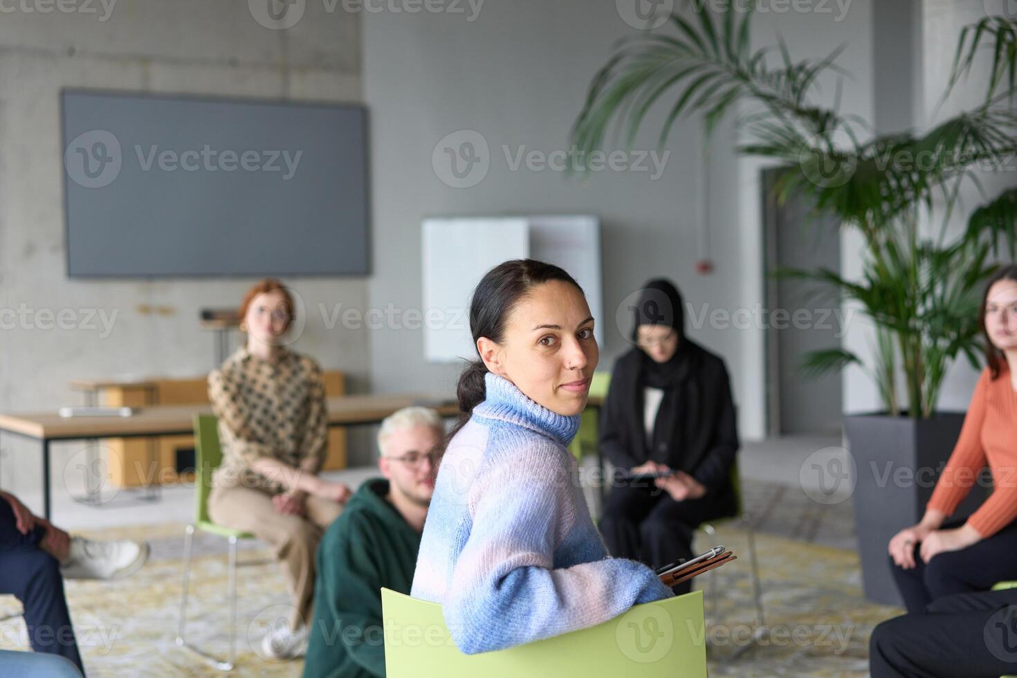 A diverse group of business professionals sits attentively in a modern office, actively participating in a training session led by an instructor, focusing on the latest technological advancements in photo