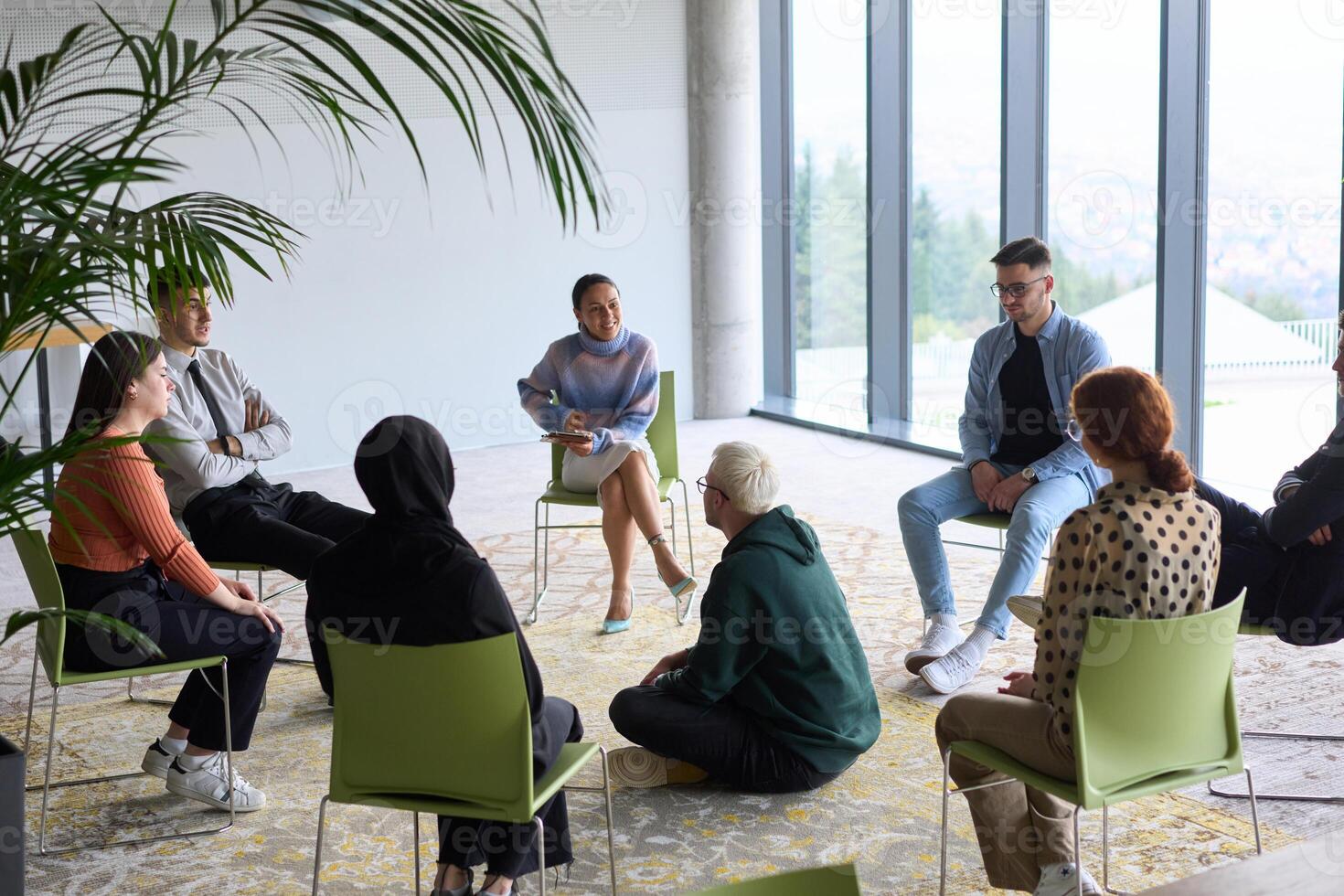 Corporate business team meeting with a manager or coach. Group of happy diverse, multiracial people sitting in a circle photo