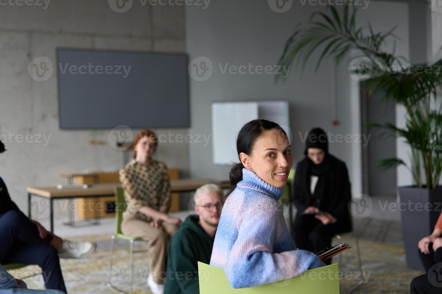 A diverse group of business professionals sits attentively in a modern office, actively participating in a training session led by an instructor, focusing on the latest technological advancements in photo