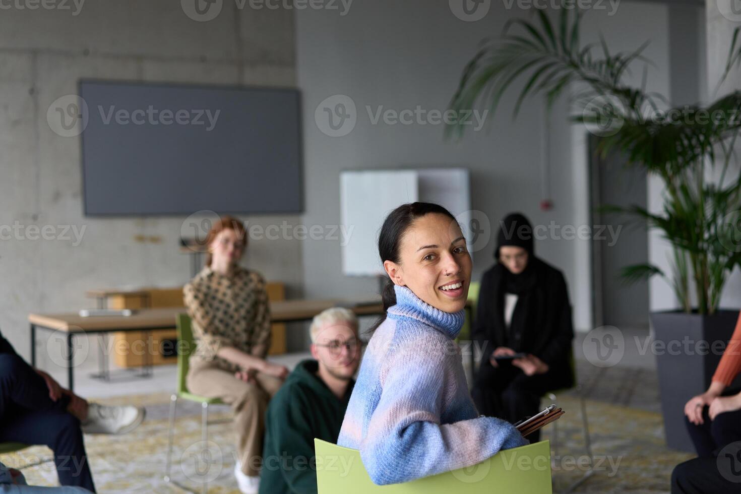 A diverse group of business professionals sits attentively in a modern office, actively participating in a training session led by an instructor, focusing on the latest technological advancements in photo