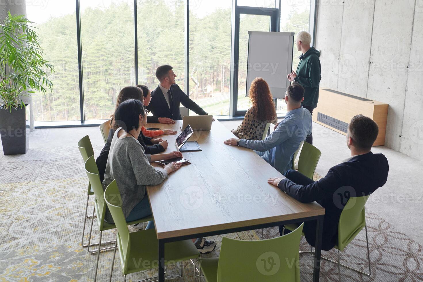 A diverse multiethnic business team engages in a collaborative meeting, discussing strategies and solutions in a modern office setting photo