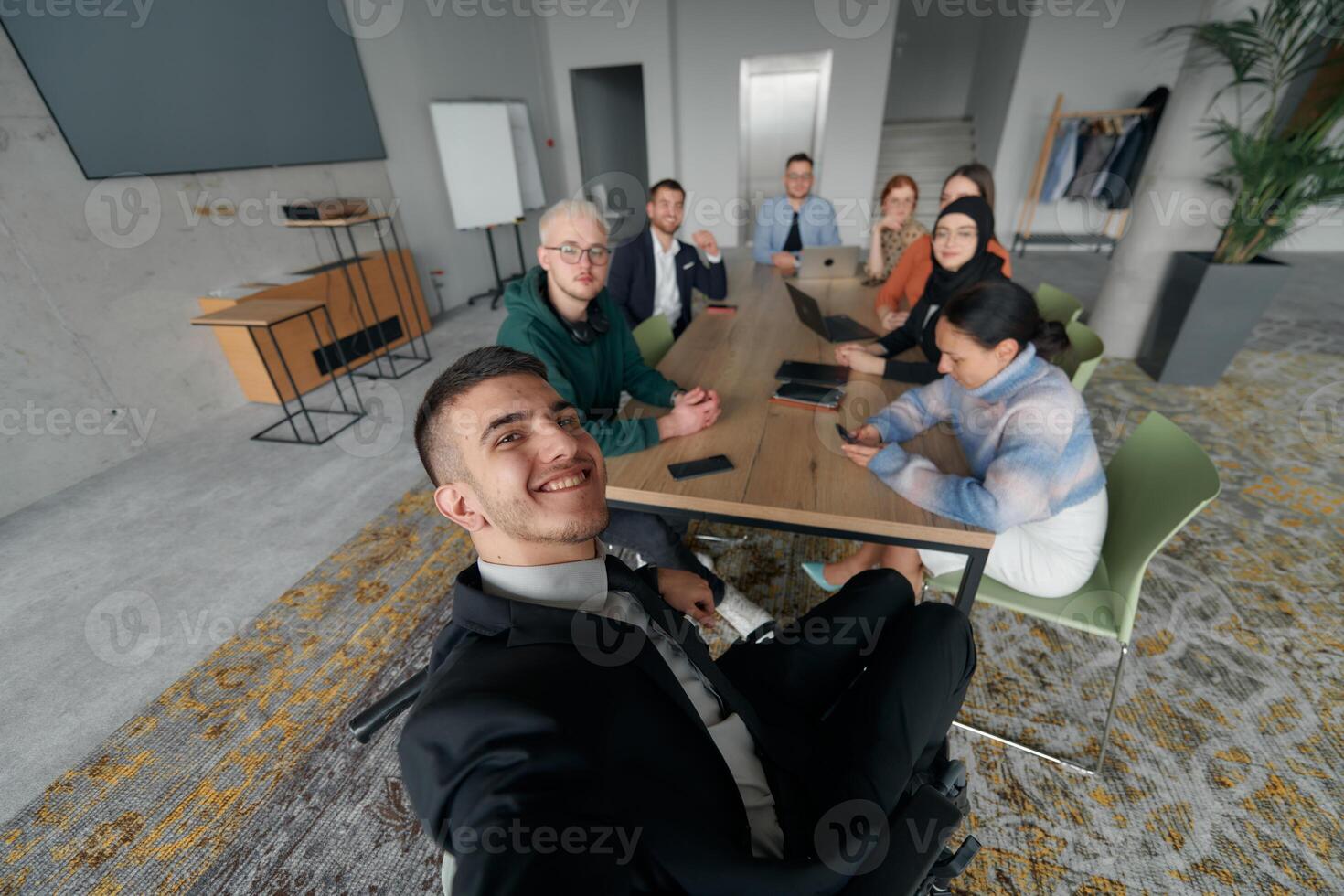 A group of business professionals taking a selfie during a break in an office meeting, capturing a moment of teamwork and collaboration in a modern workplace photo