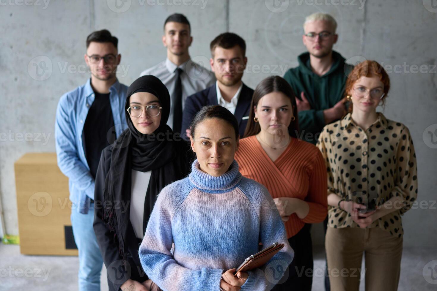 A diverse and determined team of business professionals stands confidently in an office, ready to tackle new business plans and challenges with a focus on success and growth photo