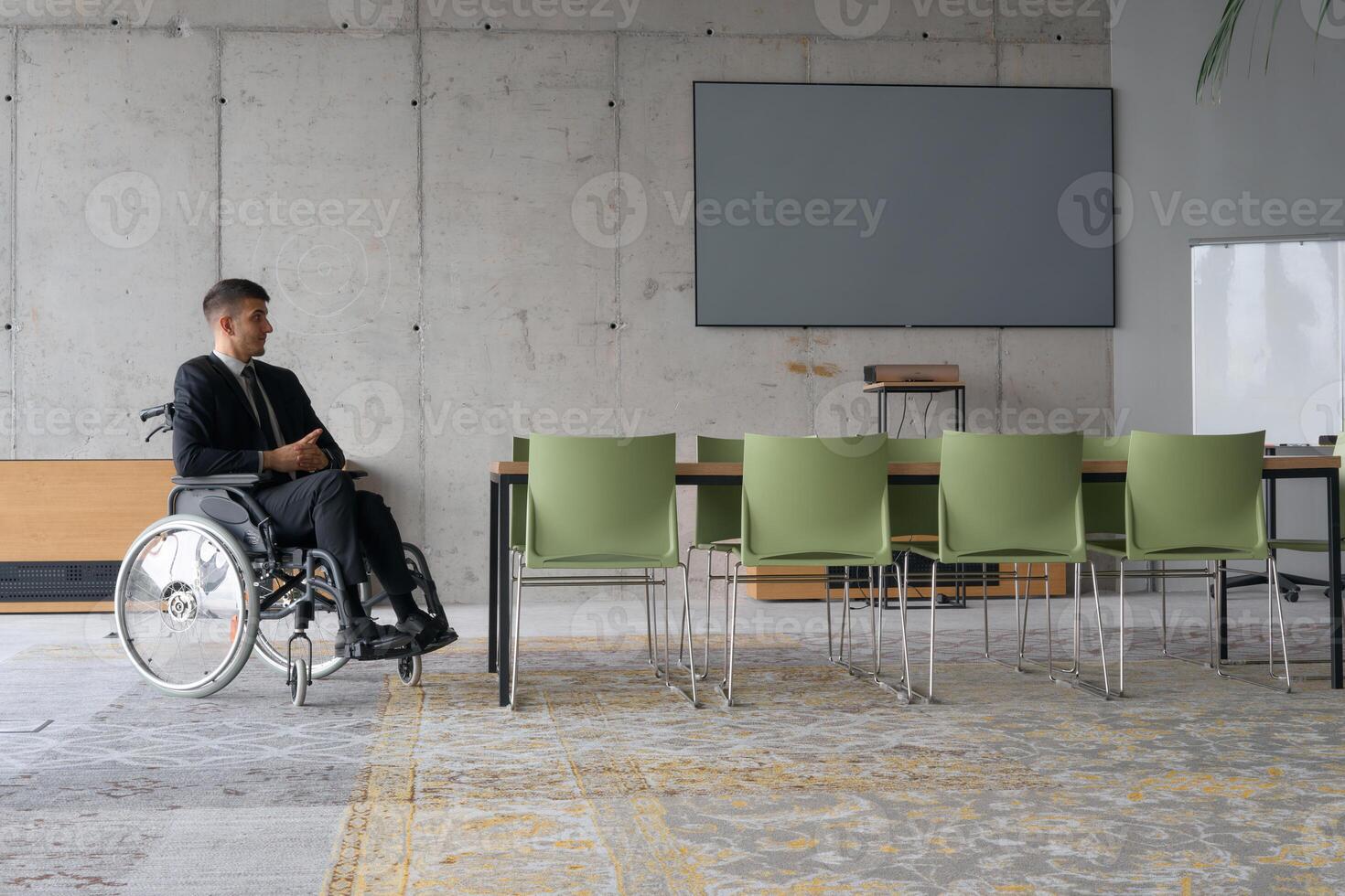 A director in a wheelchair sitting alone in an empty office, deeply reflecting on business strategies and decisions, contemplating the path forward with focused determination. photo