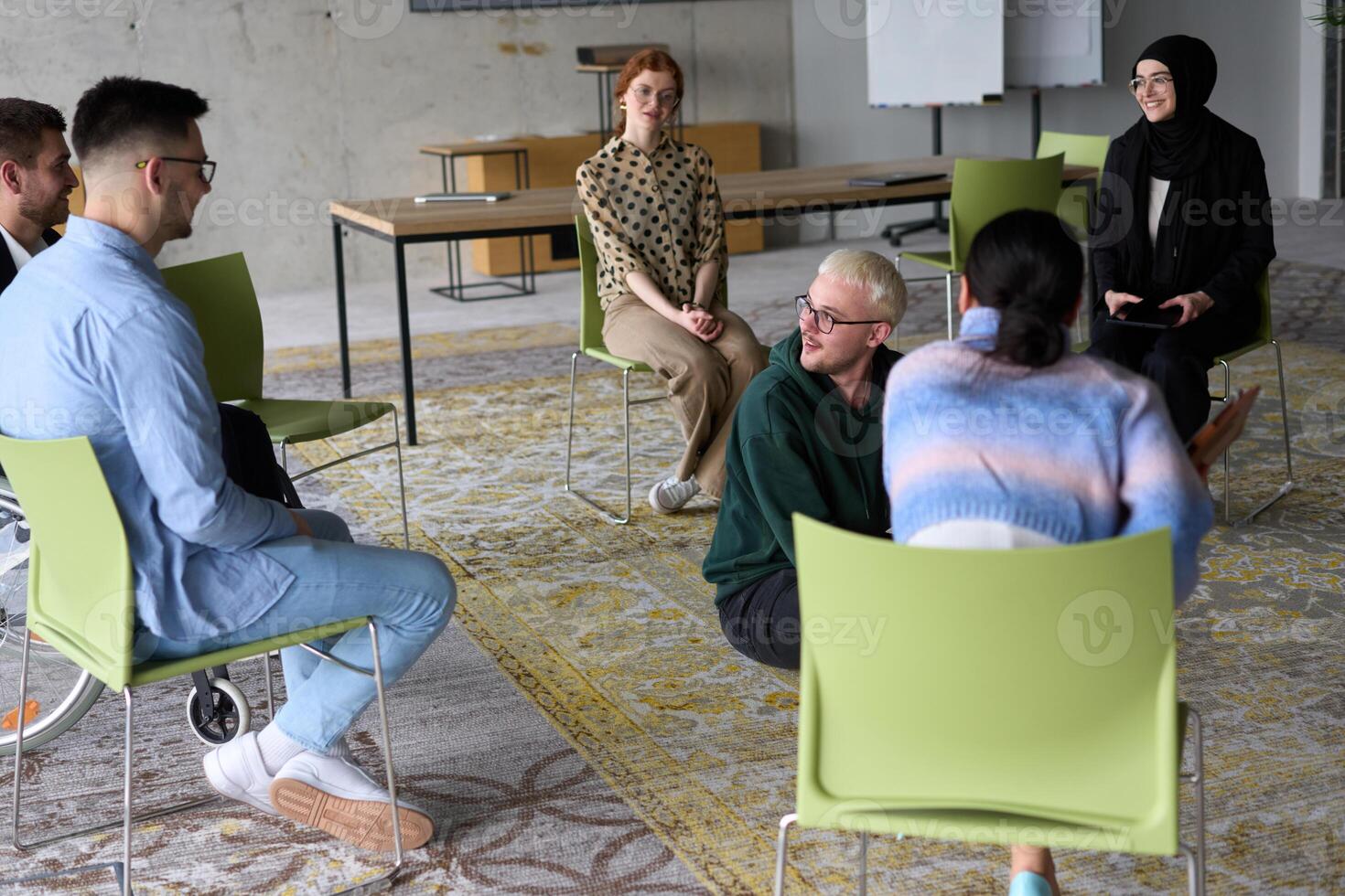 Corporate business team meeting with a manager or coach. Group of happy diverse, multiracial people sitting in a circle photo