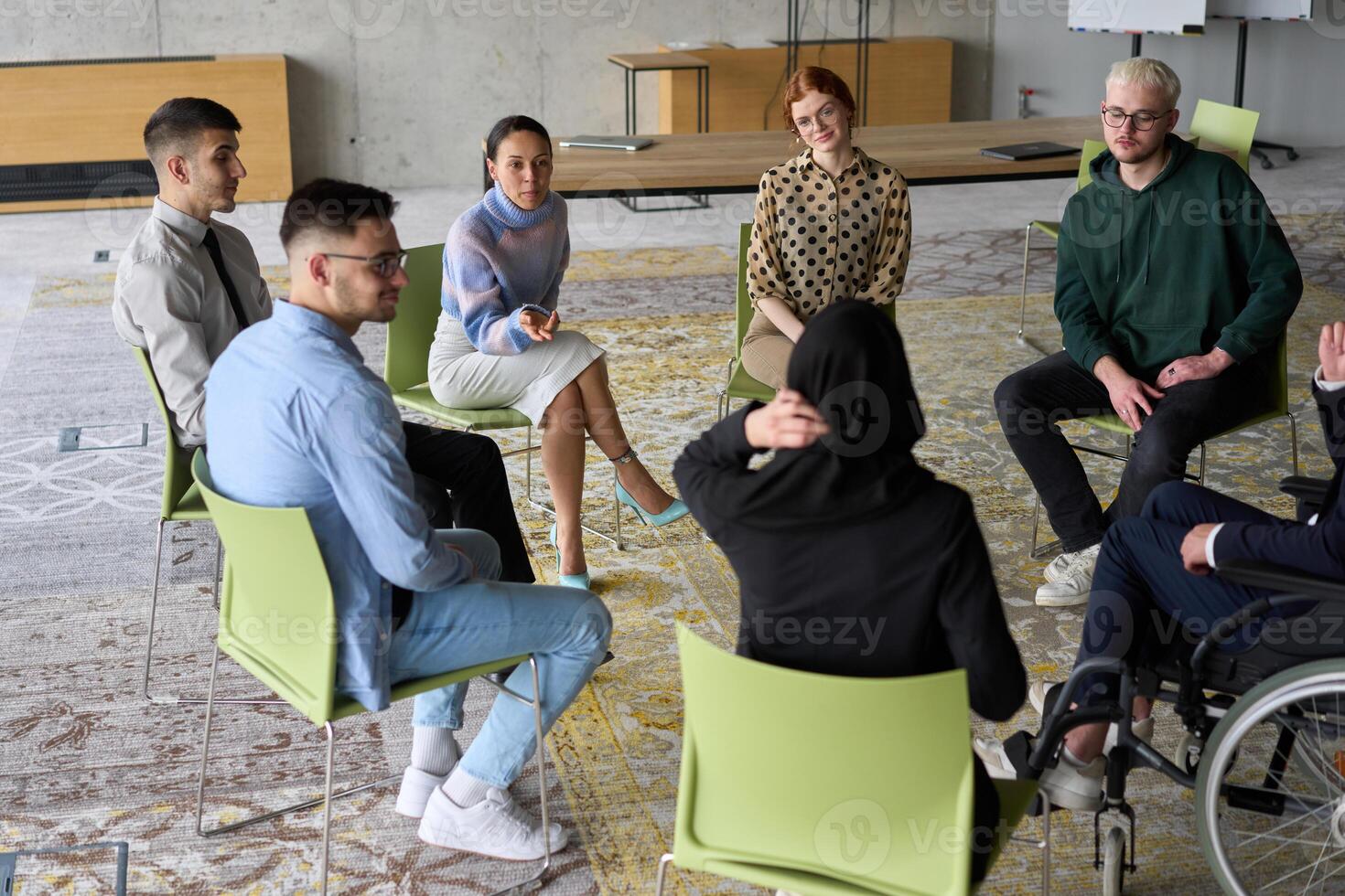 Corporate business team meeting with a manager or coach. Group of happy diverse, multiracial people sitting in a circle photo