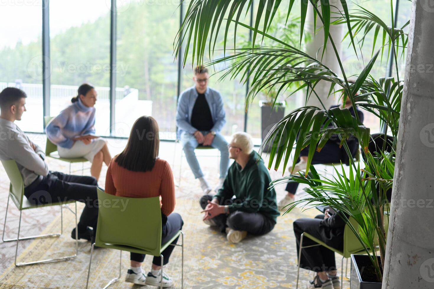 Corporate business team meeting with a manager or coach. Group of happy diverse, multiracial people sitting in a circle photo