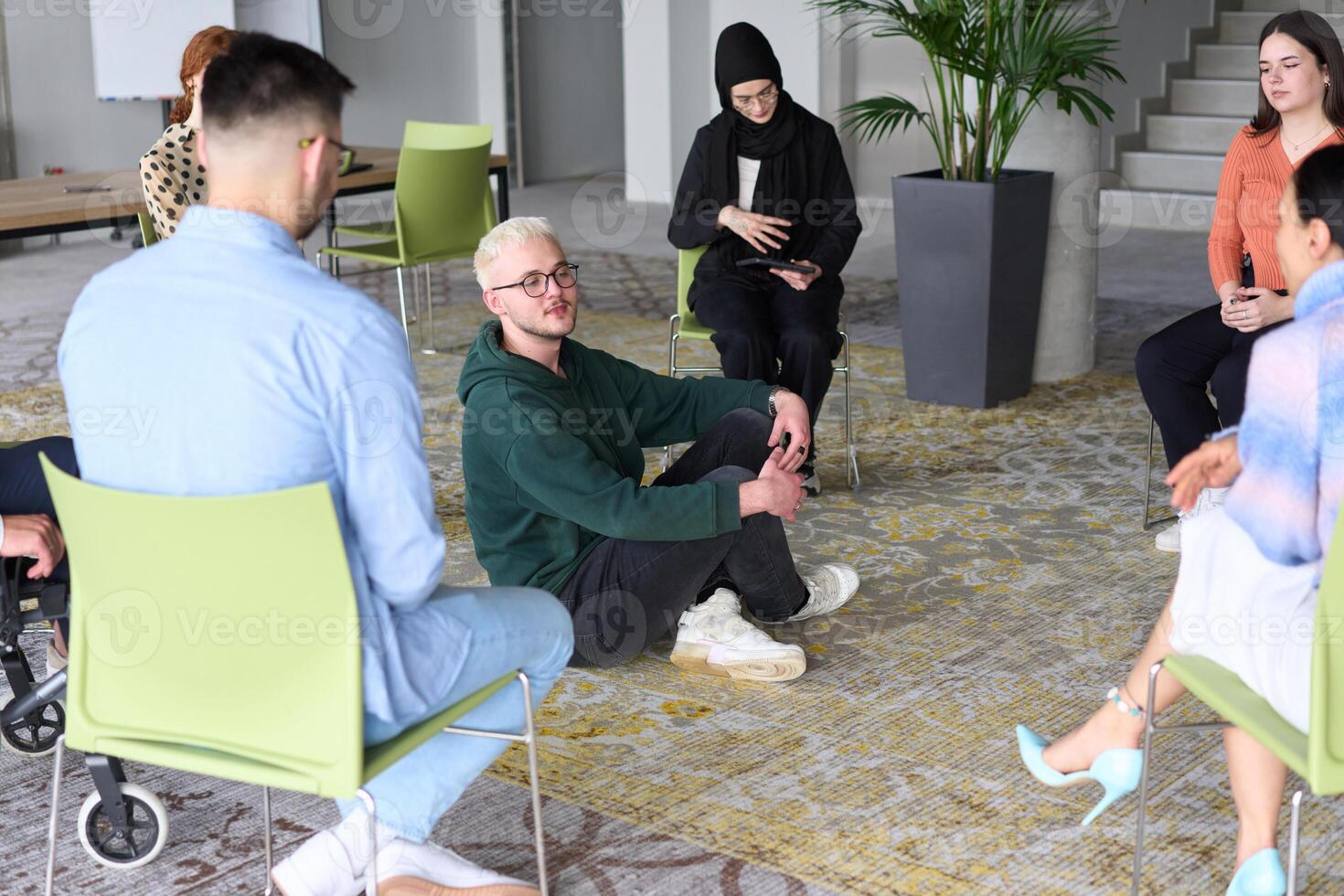 Corporate business team meeting with a manager or coach. Group of happy diverse, multiracial people sitting in a circle photo