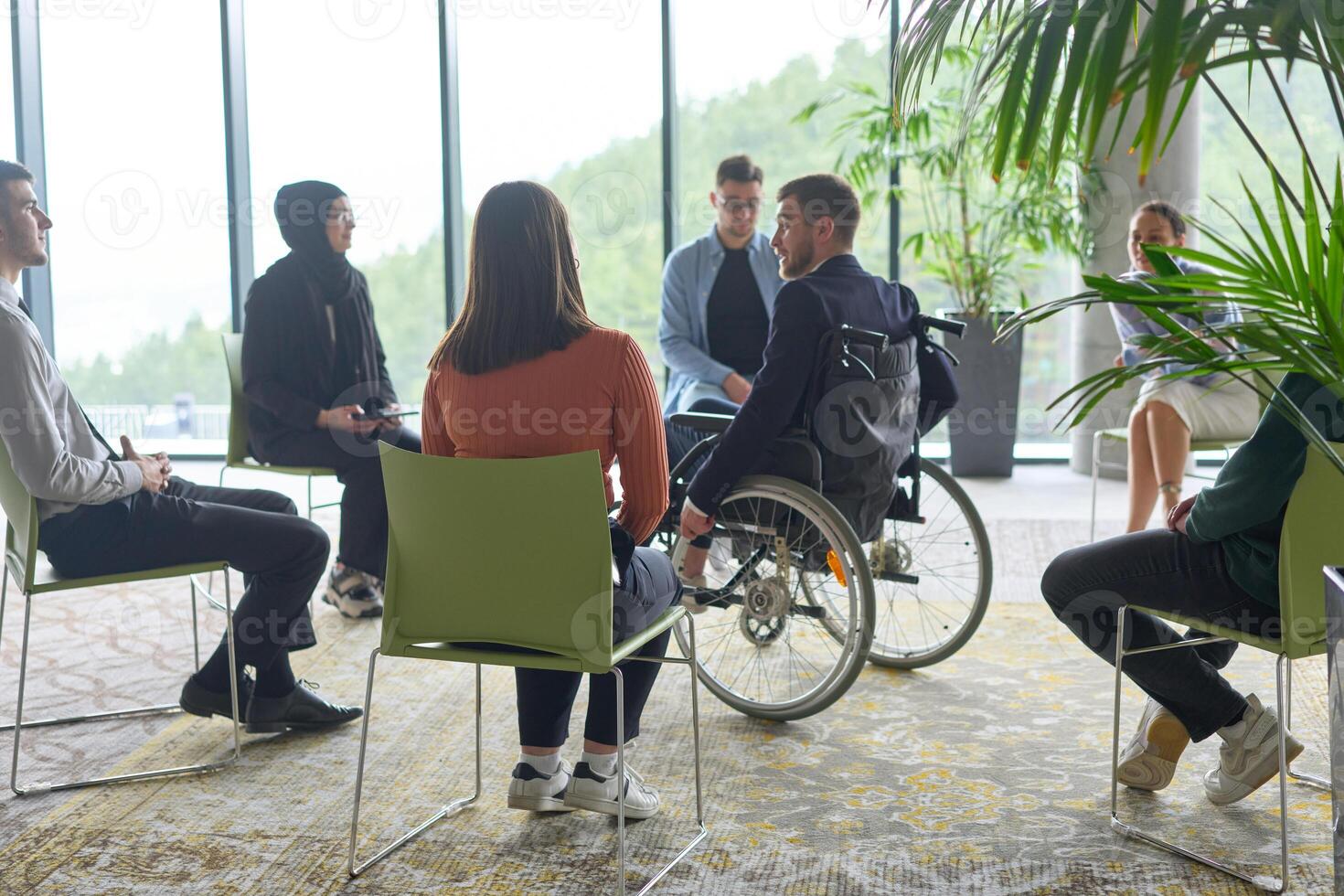 Corporate business team meeting with a manager or coach. Group of happy diverse, multiracial people sitting in a circle photo