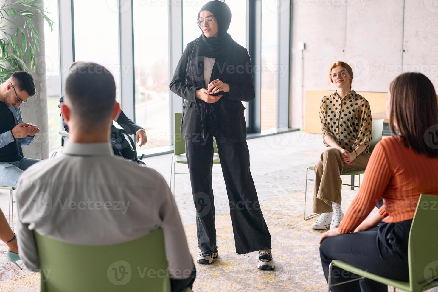 Corporate business team meeting with a manager or coach. Group of happy diverse, multiracial people sitting in a circle photo