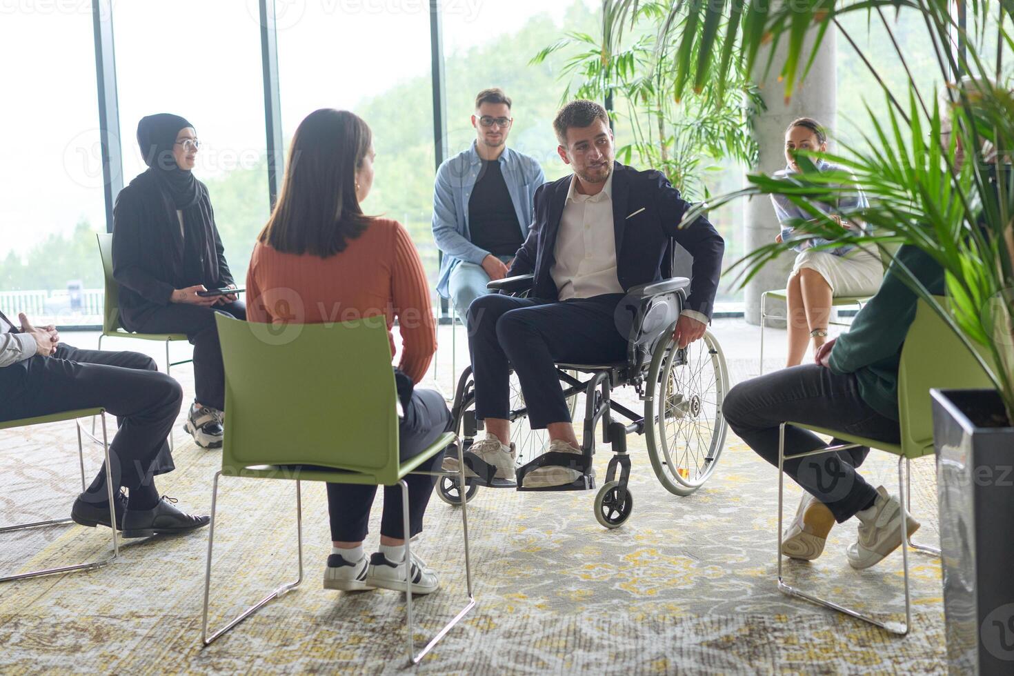 Corporate business team meeting with a manager or coach. Group of happy diverse, multiracial people sitting in a circle photo