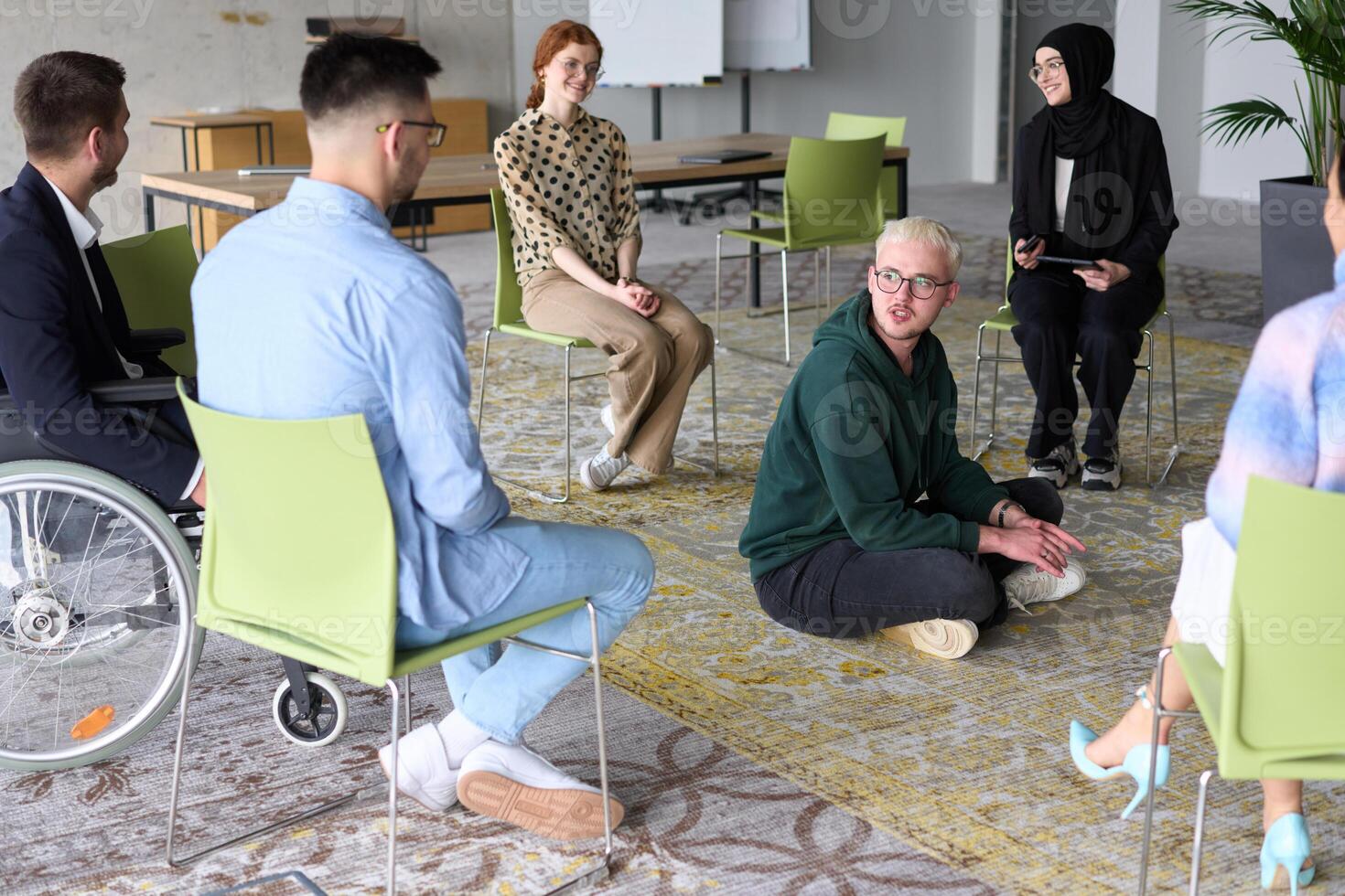 Corporate business team meeting with a manager or coach. Group of happy diverse, multiracial people sitting in a circle photo