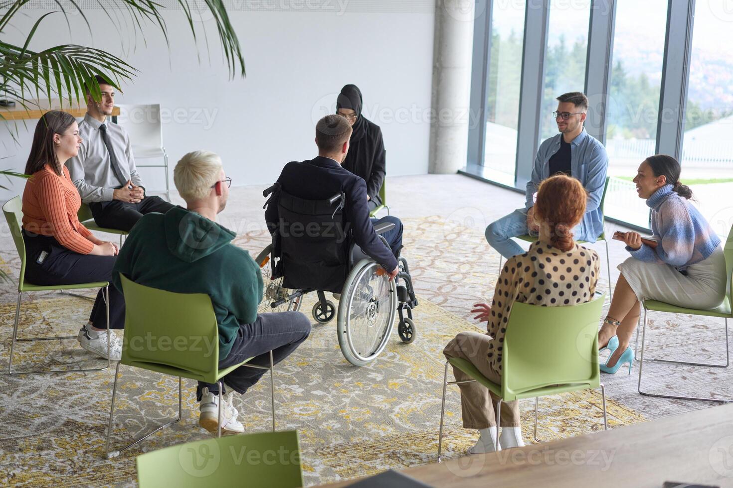 Corporate business team meeting with a manager or coach. Group of happy diverse, multiracial people sitting in a circle photo