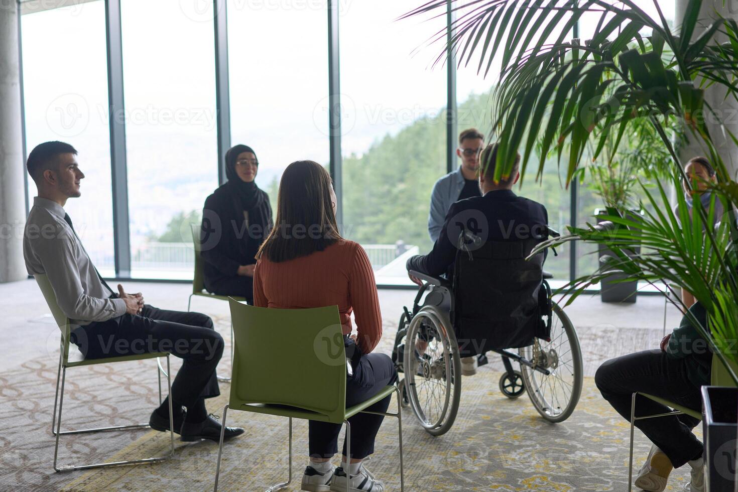 Corporate business team meeting with a manager or coach. Group of happy diverse, multiracial people sitting in a circle photo