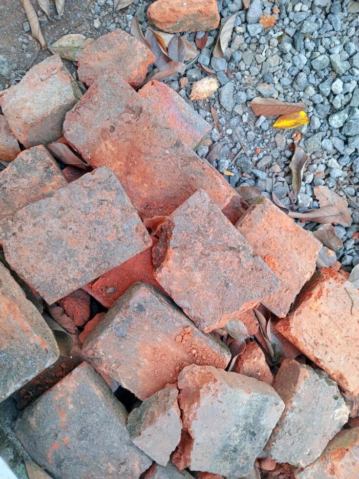 Red bricks made of clay, in broken and messy condition photo