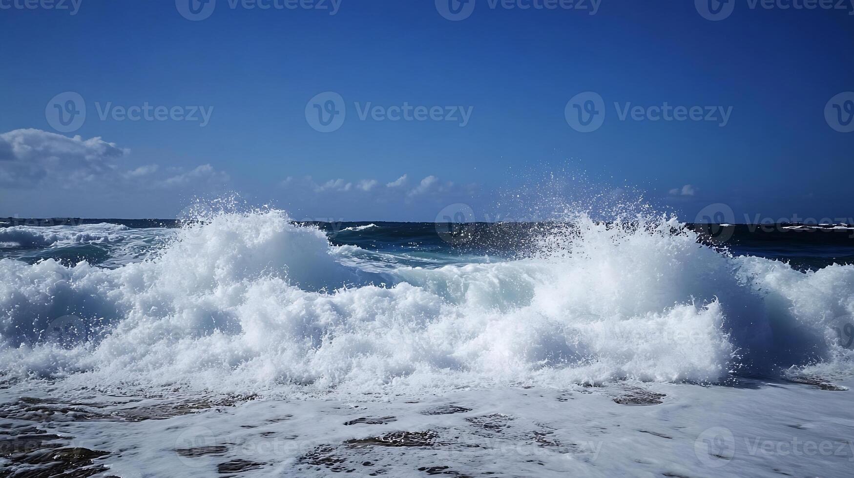 Powerful Ocean Waves Crashing Against Coastline Under Sunny Blue Sky photo