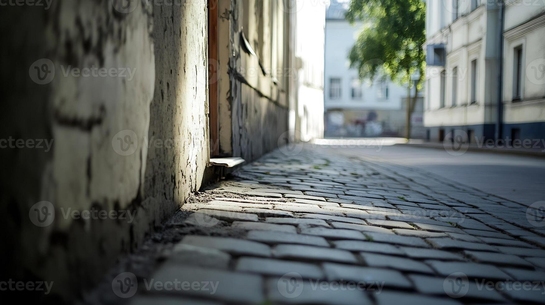 Vintage Cobblestone Alley in a Quiet Urban Setting with Sunlit Facade and Shadowed Pathways photo