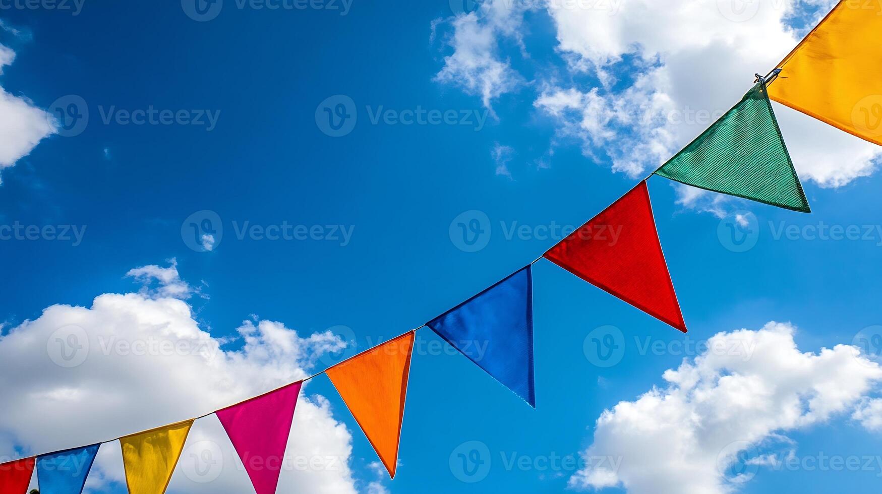 Colorful Bunting Flags Against a Bright Blue Sky with Fluffy White Clouds photo
