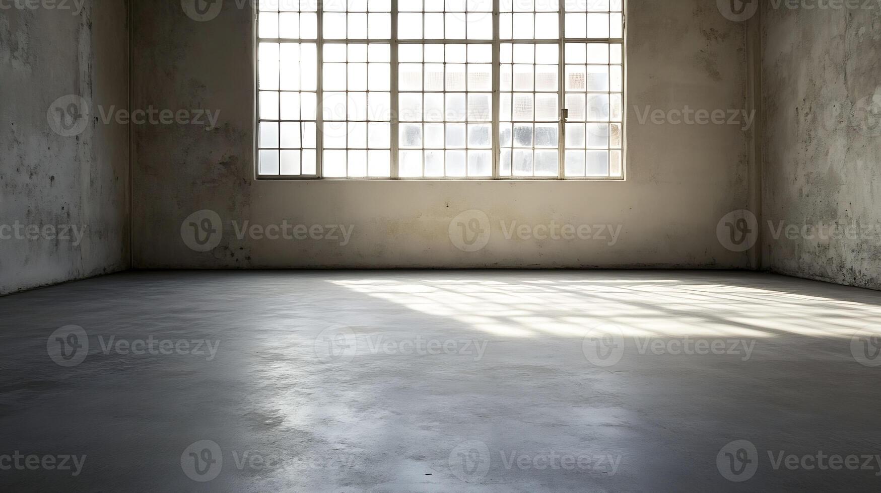 Dimly lit empty industrial room with concrete floor and grid windows reflecting soft daylight photo