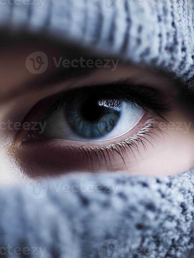 Mysterious Blue Eye Hidden Behind Knitted Fabric Conveying Intrigue and Curiosity photo