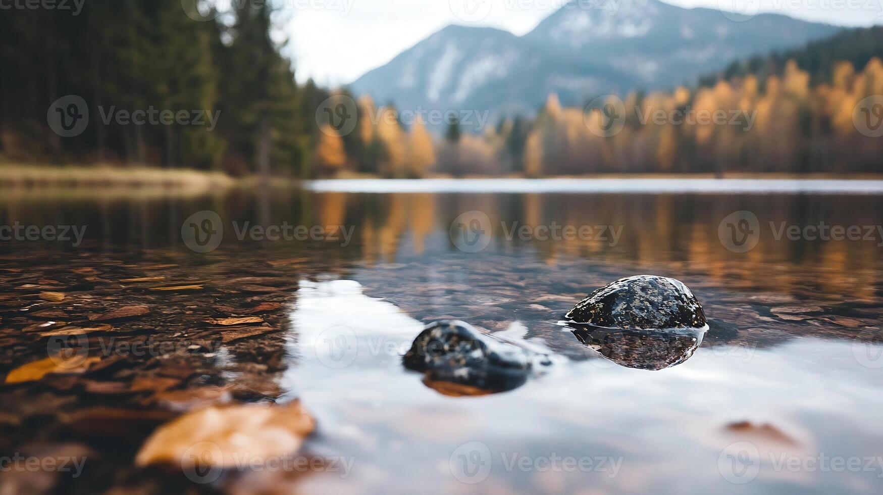 Pristine Mountain Lake Reflecting Autumn Foliage with Rocky Shoreline and Pine Forests in Tranquil Setting photo
