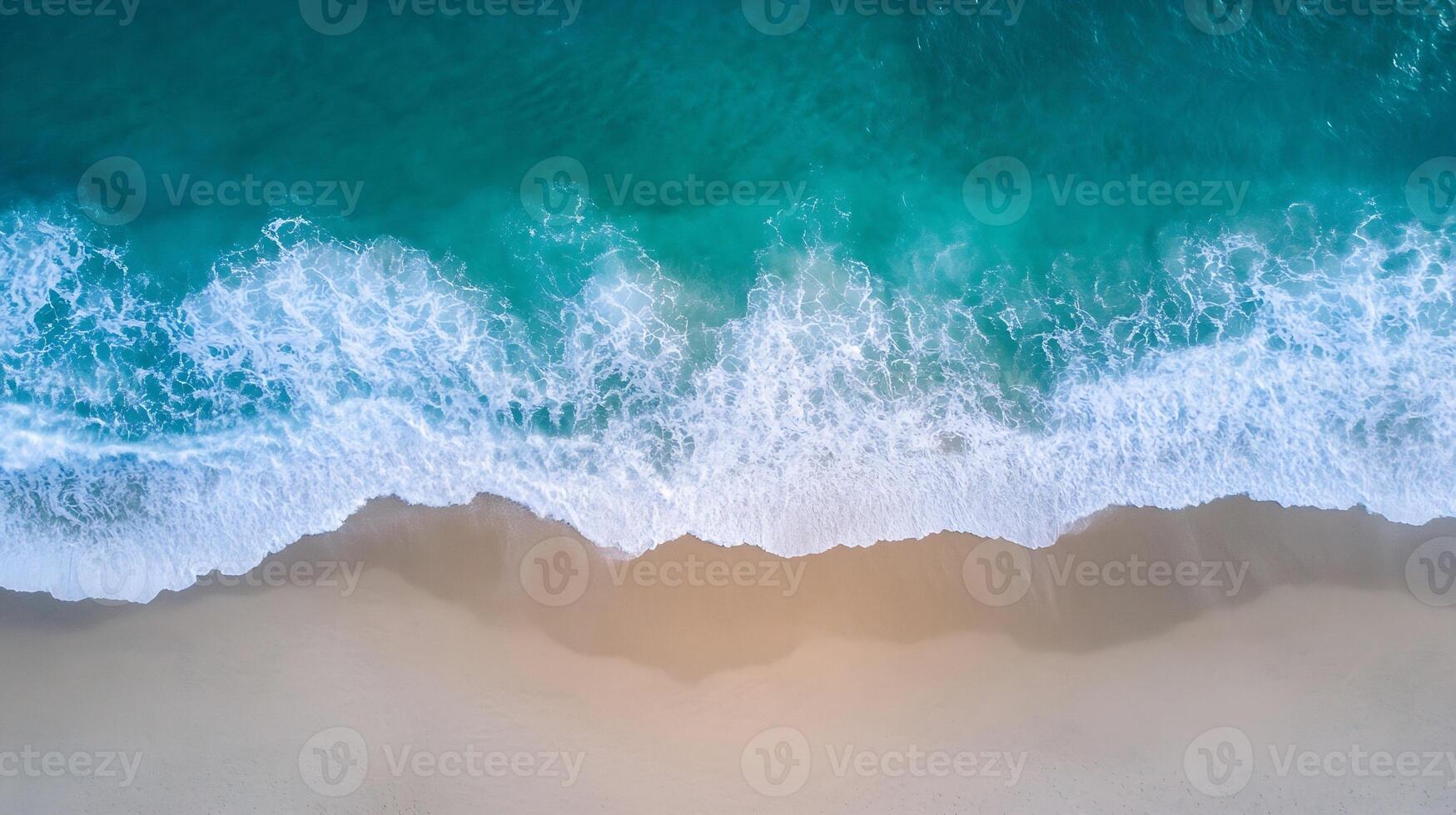 Aerial view of ocean waves gently crashing onto a pristine sandy beach shoreline photo