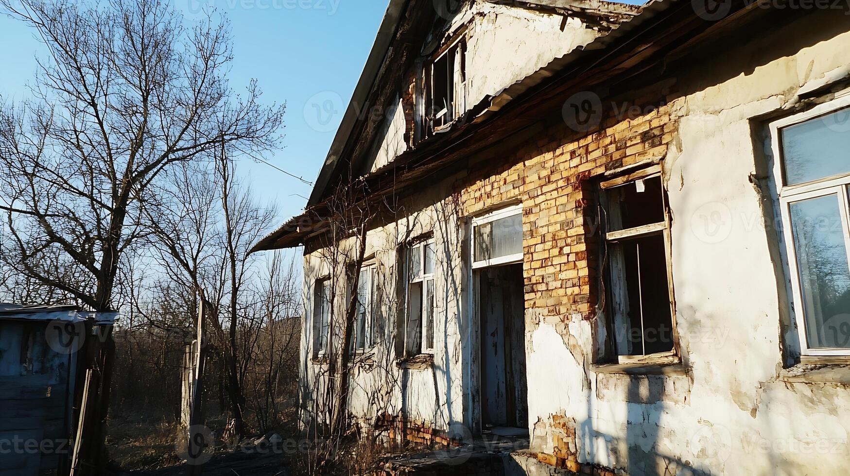 Abandoned Weathered House with Broken Windows in Remote Winter Landscape photo