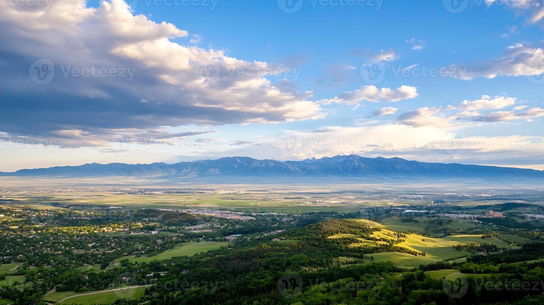 Vast Green Valley and Distant Mountains Under a Bright Sky and Fluffy Clouds photo