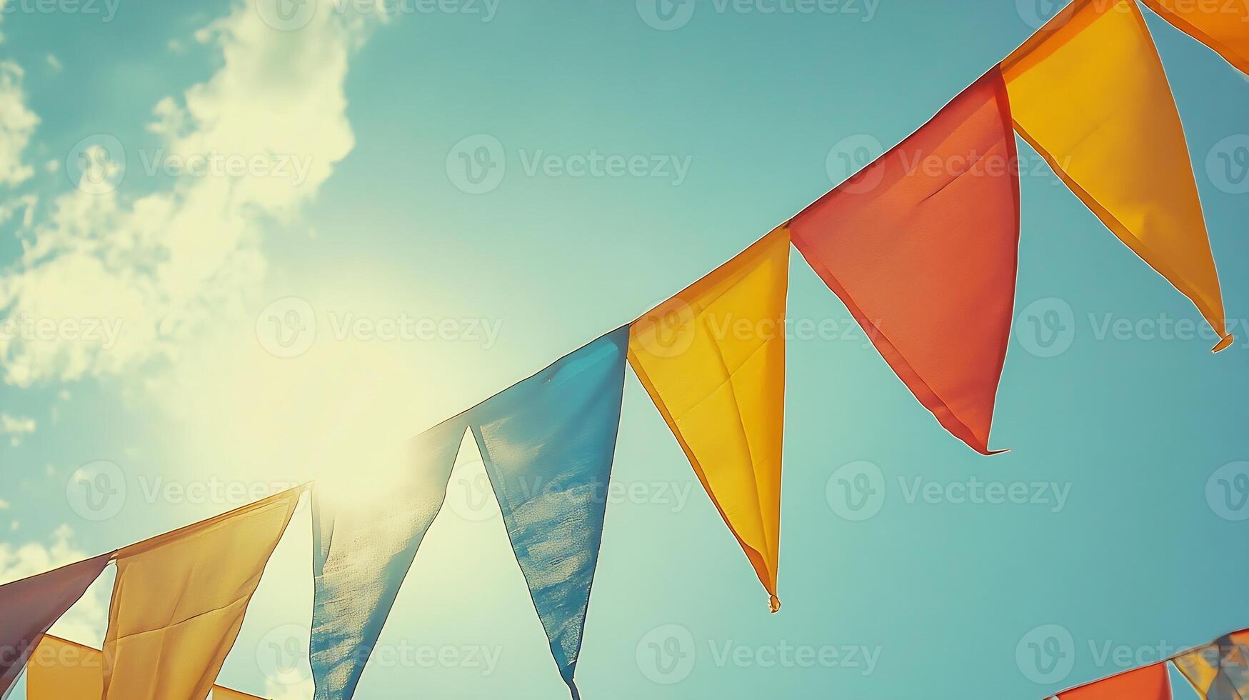 Sunlit Colorful Bunting Flags Flapping Joyfully Under a Clear Blue Sky photo