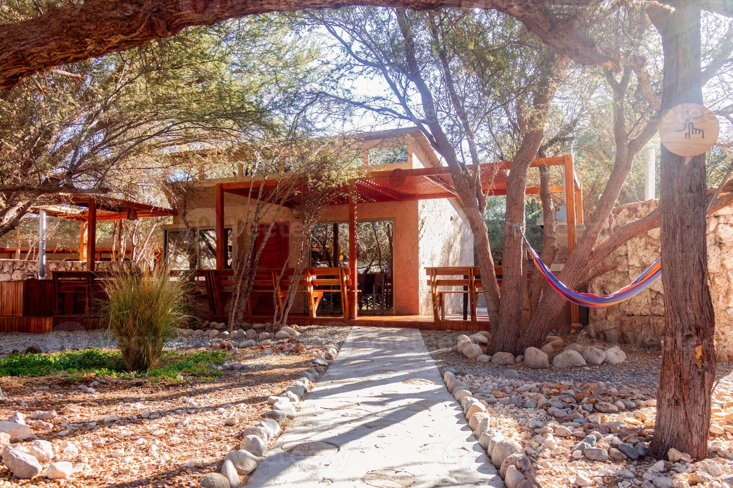 a small house with a hammock hanging from a tree photo