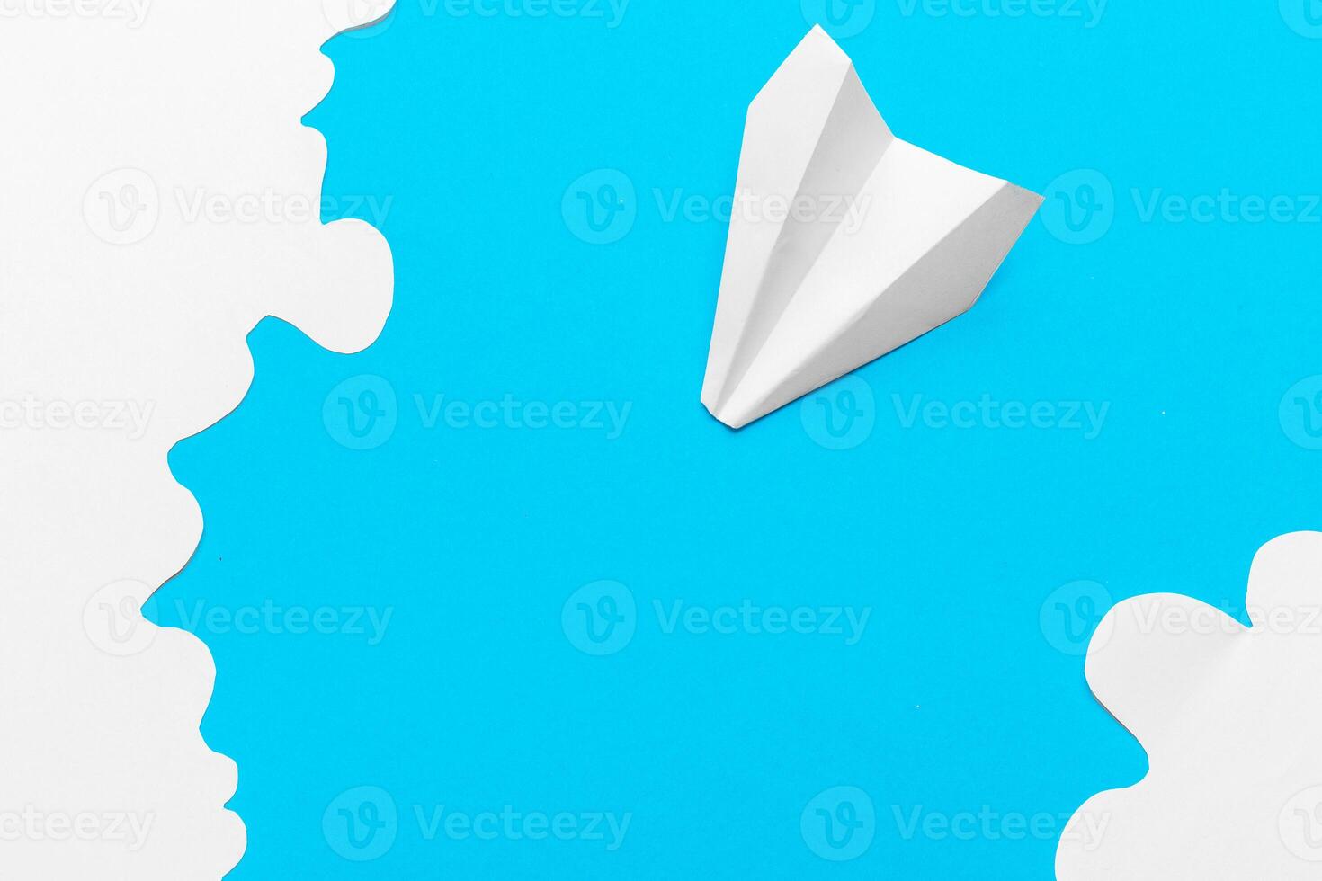 Flying paper plane in the clouds on a blue background. Concept of flight, travel, transfer photo