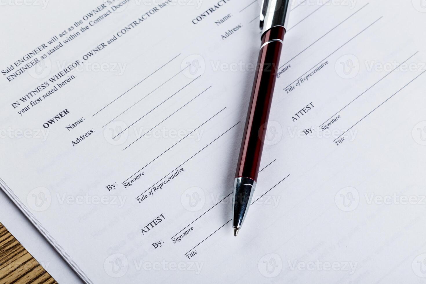 Pen and contract papers on wooden desk photo