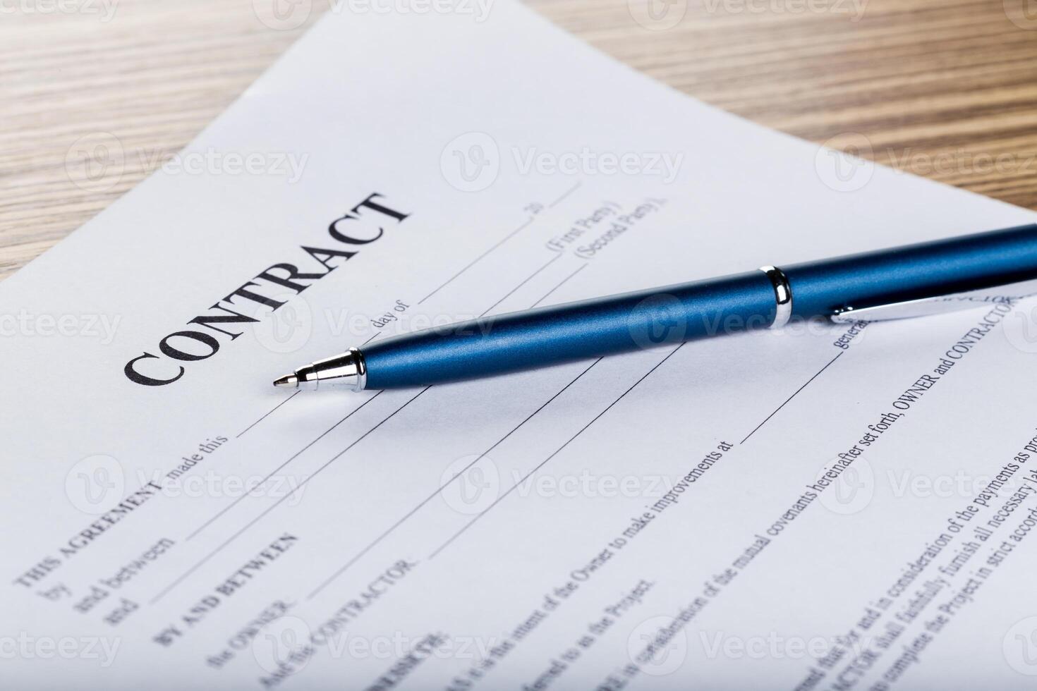Pen and contract papers on wooden desk photo