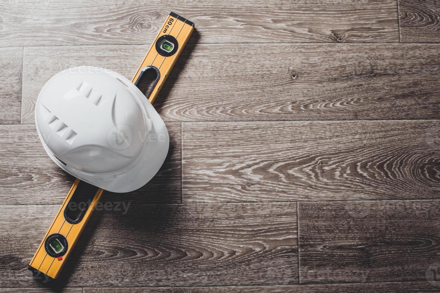 Safety helmet and tools to architect on wooden background photo