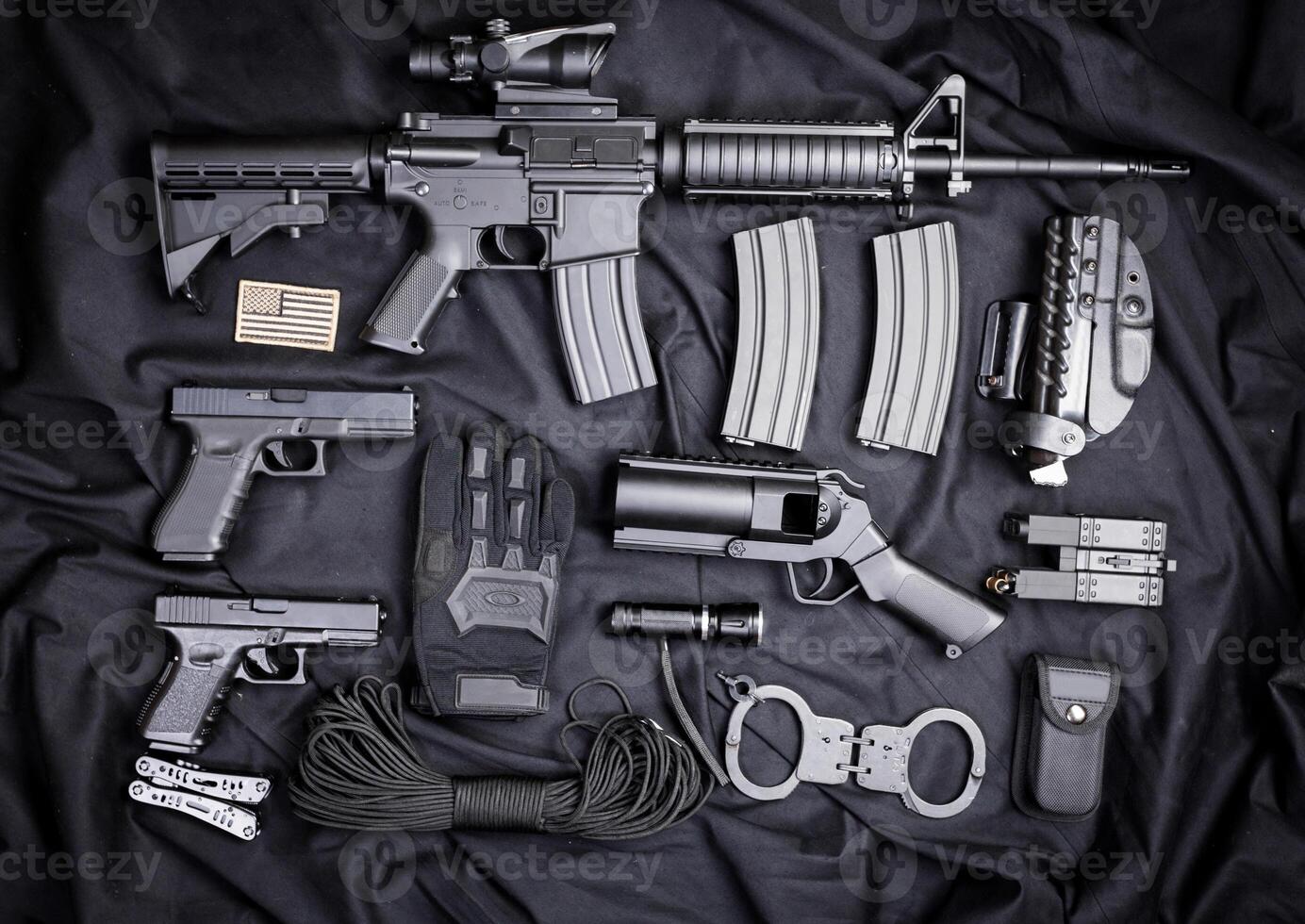 Rifle, gun, knife with sheath, compass and notebook with pen on on black cloth photo
