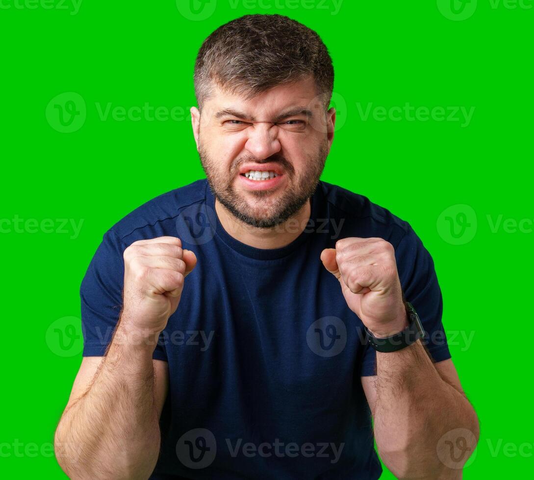 A strong man with fists raised, smiling confidently, on a bright green background photo