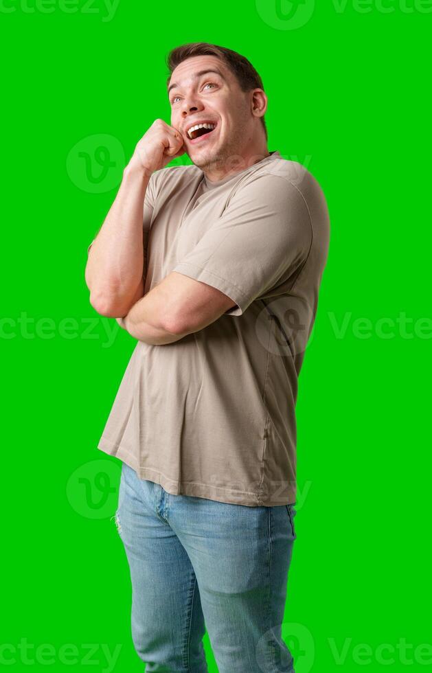 Smiling man in a beige shirt poses against a bright green background photo