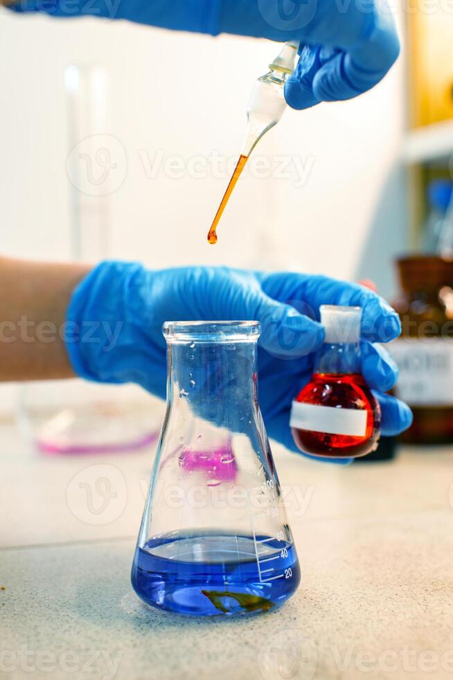 Chemistry experiment involves mixing colored liquids in laboratory setting with precise droplet measurements photo