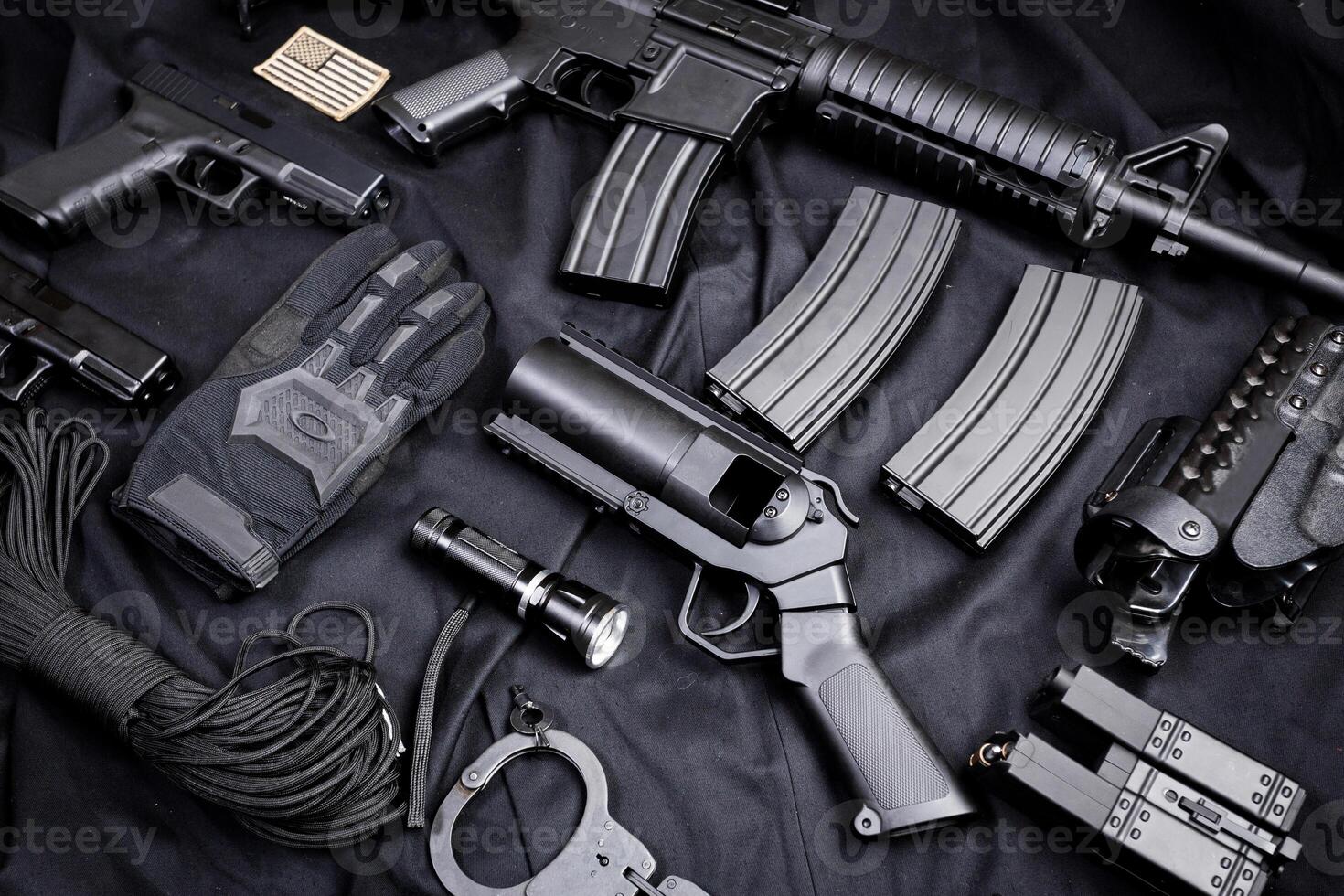 Rifle, gun, knife with sheath, compass and notebook with pen on on black cloth photo
