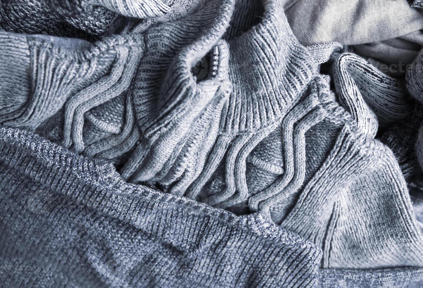 Warm knitted textile stack with the different texture in grey color palette close up photo