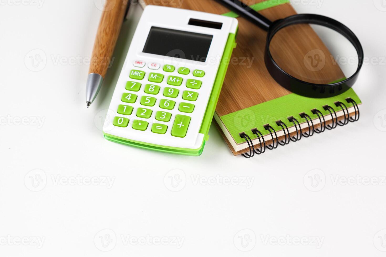 Calculator with a magnifying glass on a white background photo