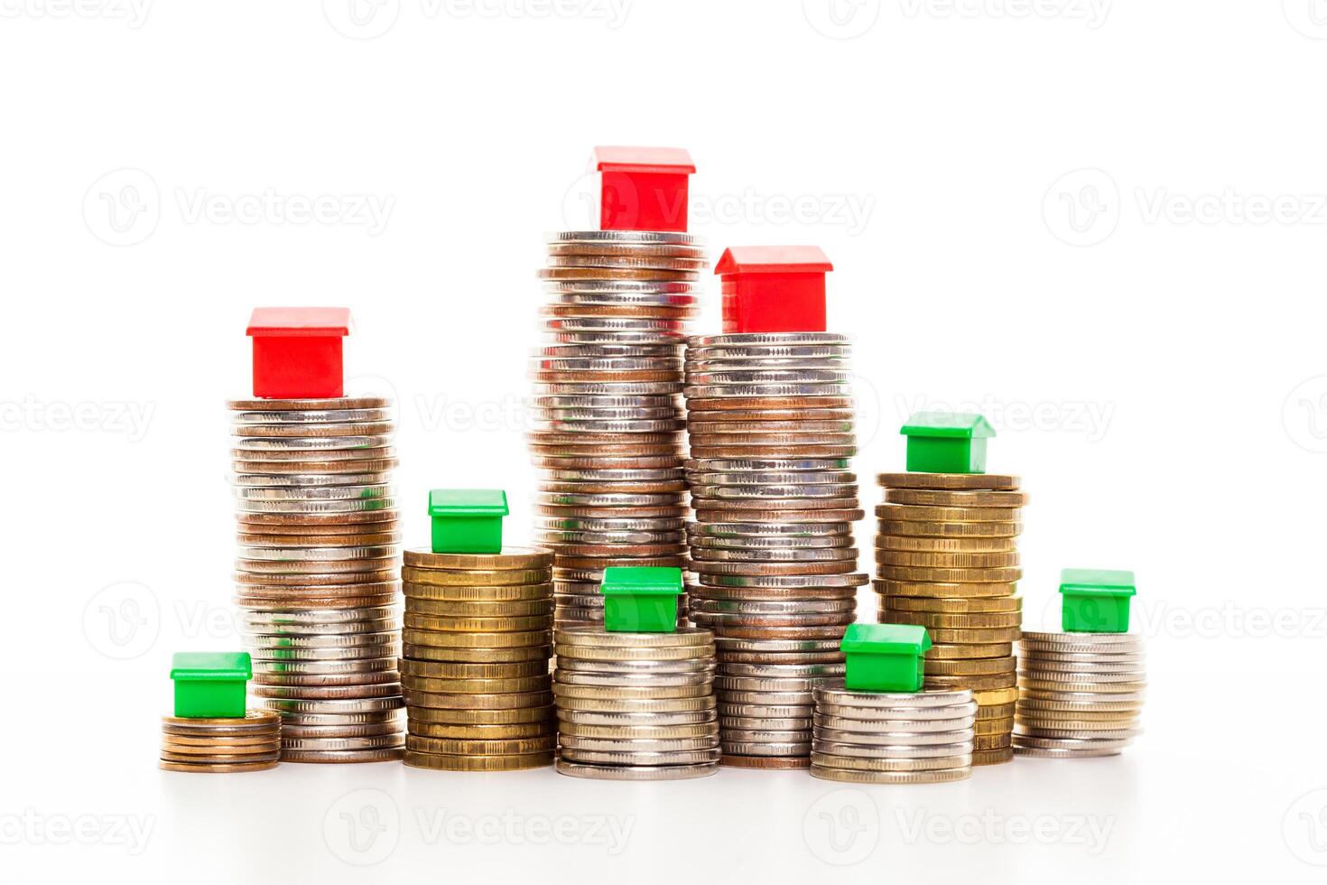 Stacks of coins, green and red home. Mortgage concept by money house from coins photo