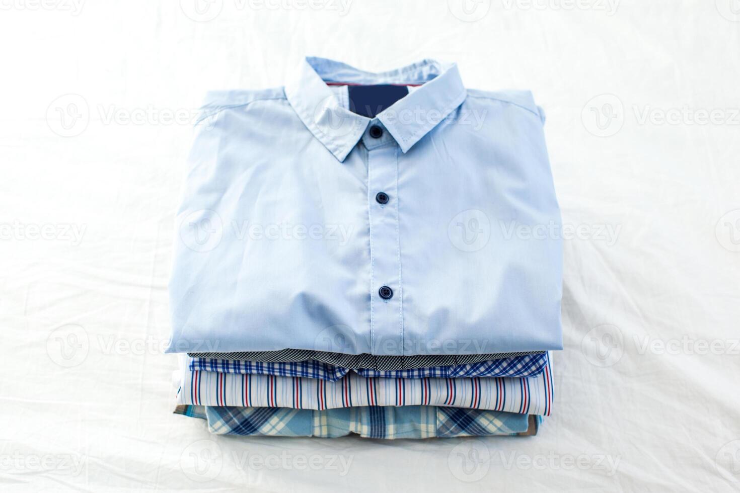 close up of ironed and folded shirts on table at home photo