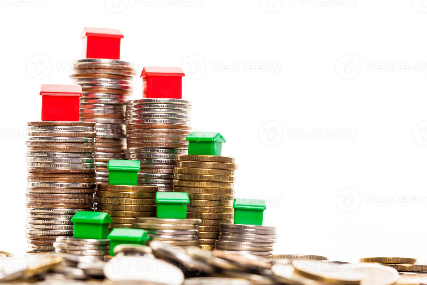 Stacks of coins, green and red home. Mortgage concept by money house from coins photo