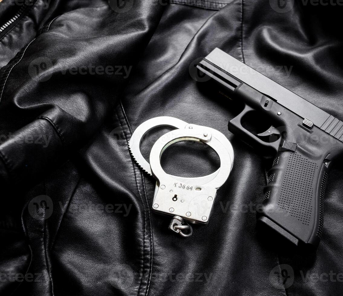 Rifle, gun, knife with sheath, compass and notebook with pen on on black cloth photo