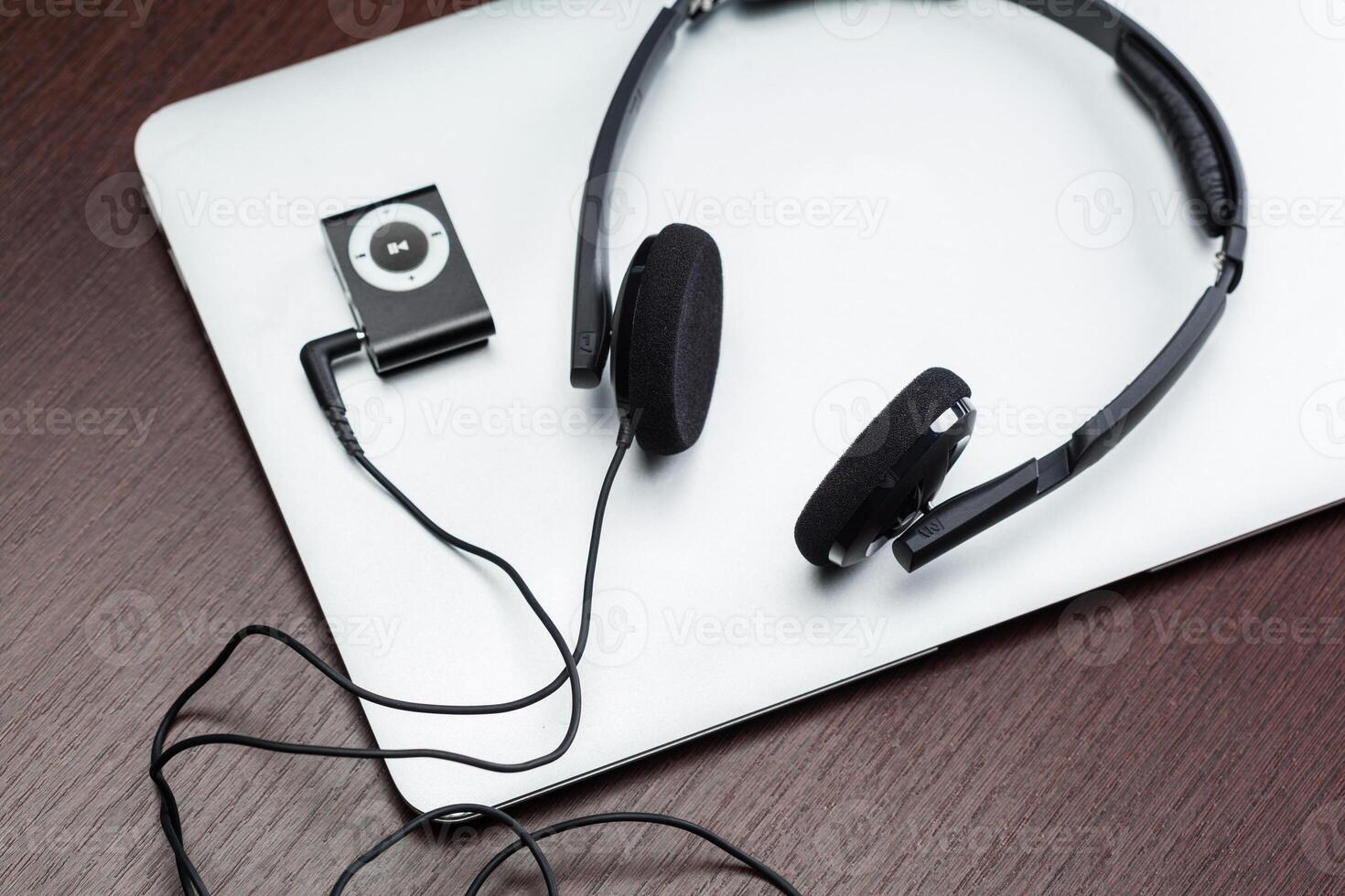 Headphones with laptop on table close up photo