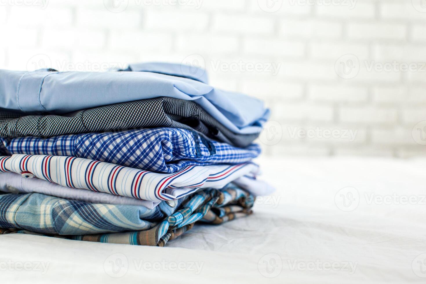 close up of ironed and folded shirts on table at home photo