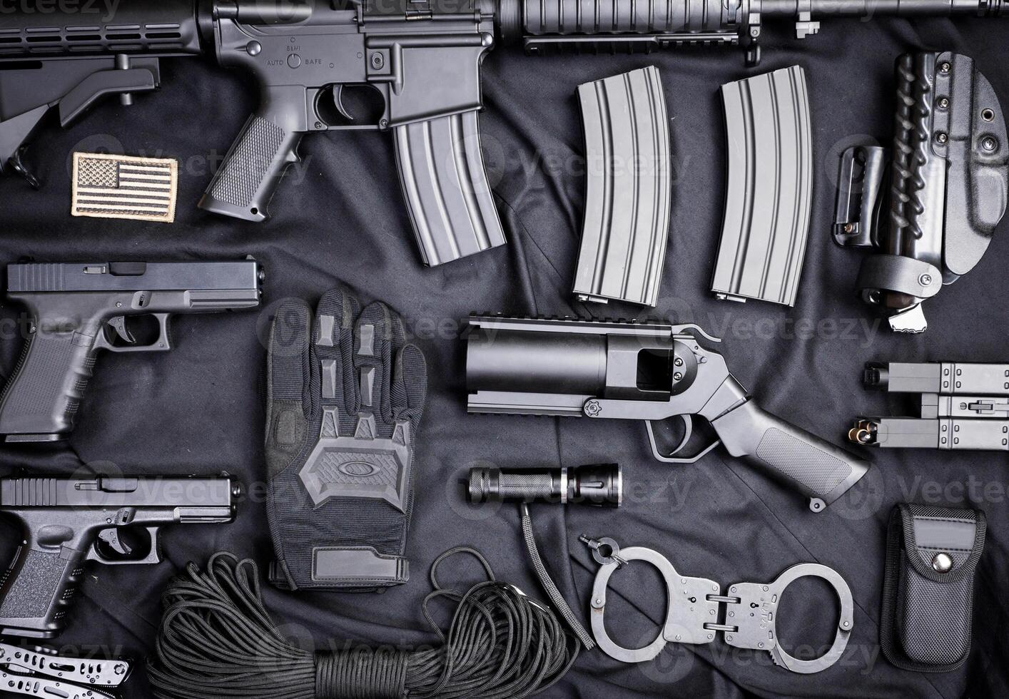Rifle, gun, knife with sheath, compass and notebook with pen on on black cloth photo